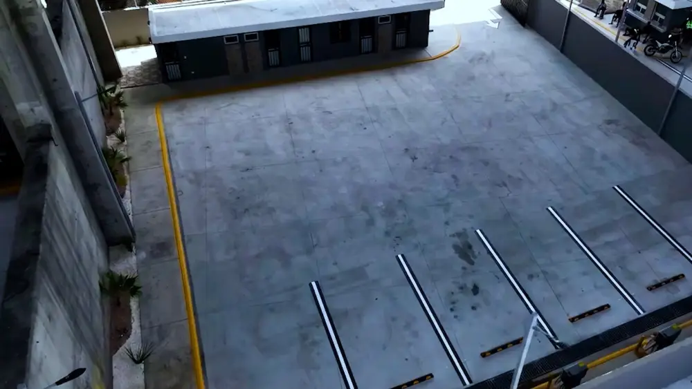 Losa de estacionamiento con topes y señalización amarilla